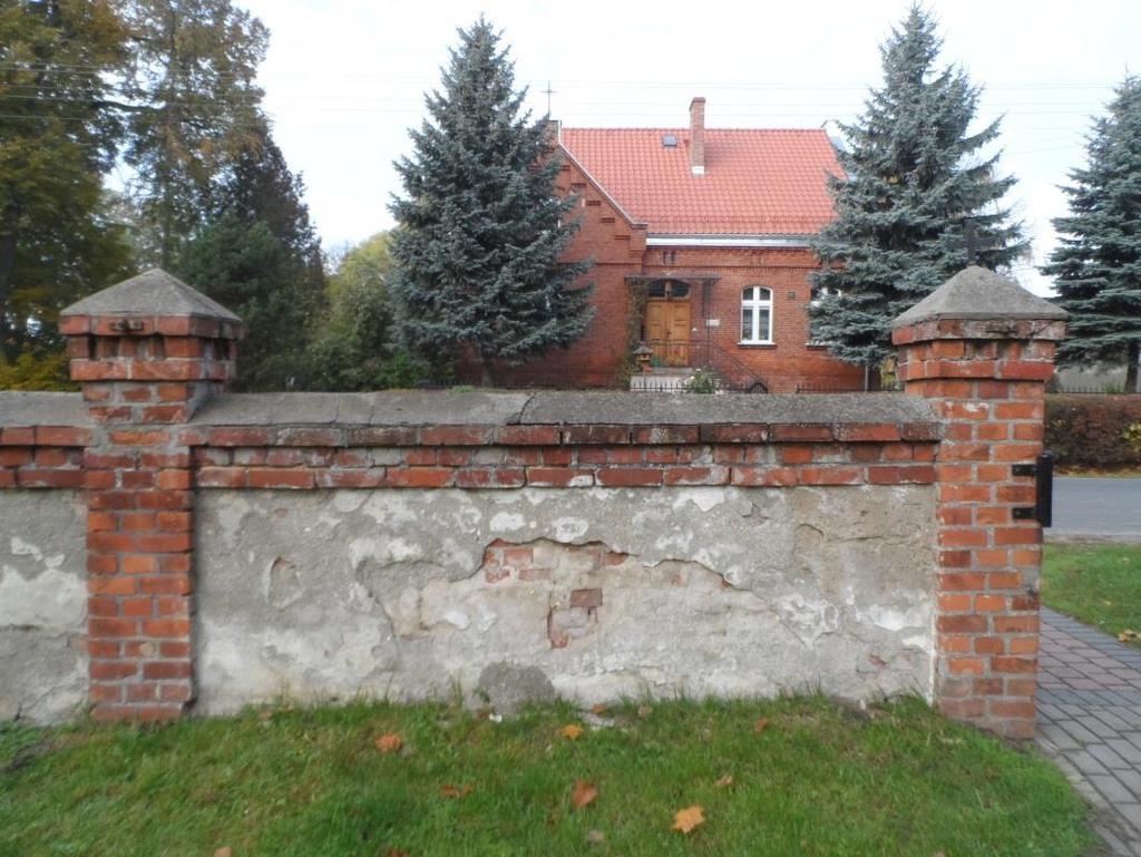 Widok typowego przęsła od strony wewnętrznej Część dolna muru ogrodzenia fundamentowa jest murowana z cegły pełnej i ma grubość 32 cm.
