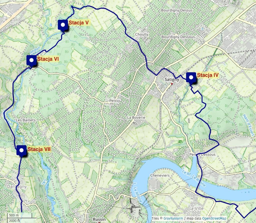 Miniesz zabudowania nr. 25 po prawej stronie, na skrzyżowaniu, skręć w prawo, idź chodnikiem w kierunku miejscowości Aire-la-Ville. Na rondzie skręć w prawo i przejdź na drugą stronę ulicy.