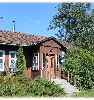 CERAMICZNĄ. PRZEDNIĄ ŚCIANĘ BUDYNKU ZDOBI GANEK, USYTUOWANY NA KAMIENNEJ PODMURÓWCE. DO GŁÓWNEGO WEJŚCIA PROWADZĄ NIEWYSOKIE SCHODY.