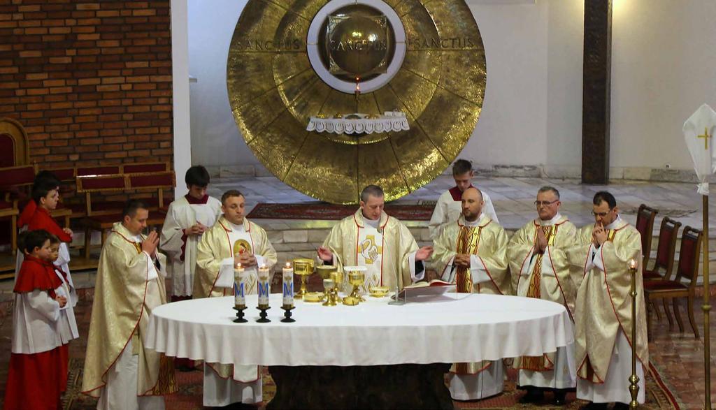 Eugeniusz Burzyk, w asyście diakona i koncelebrze kapłanów pracujących w parafii.