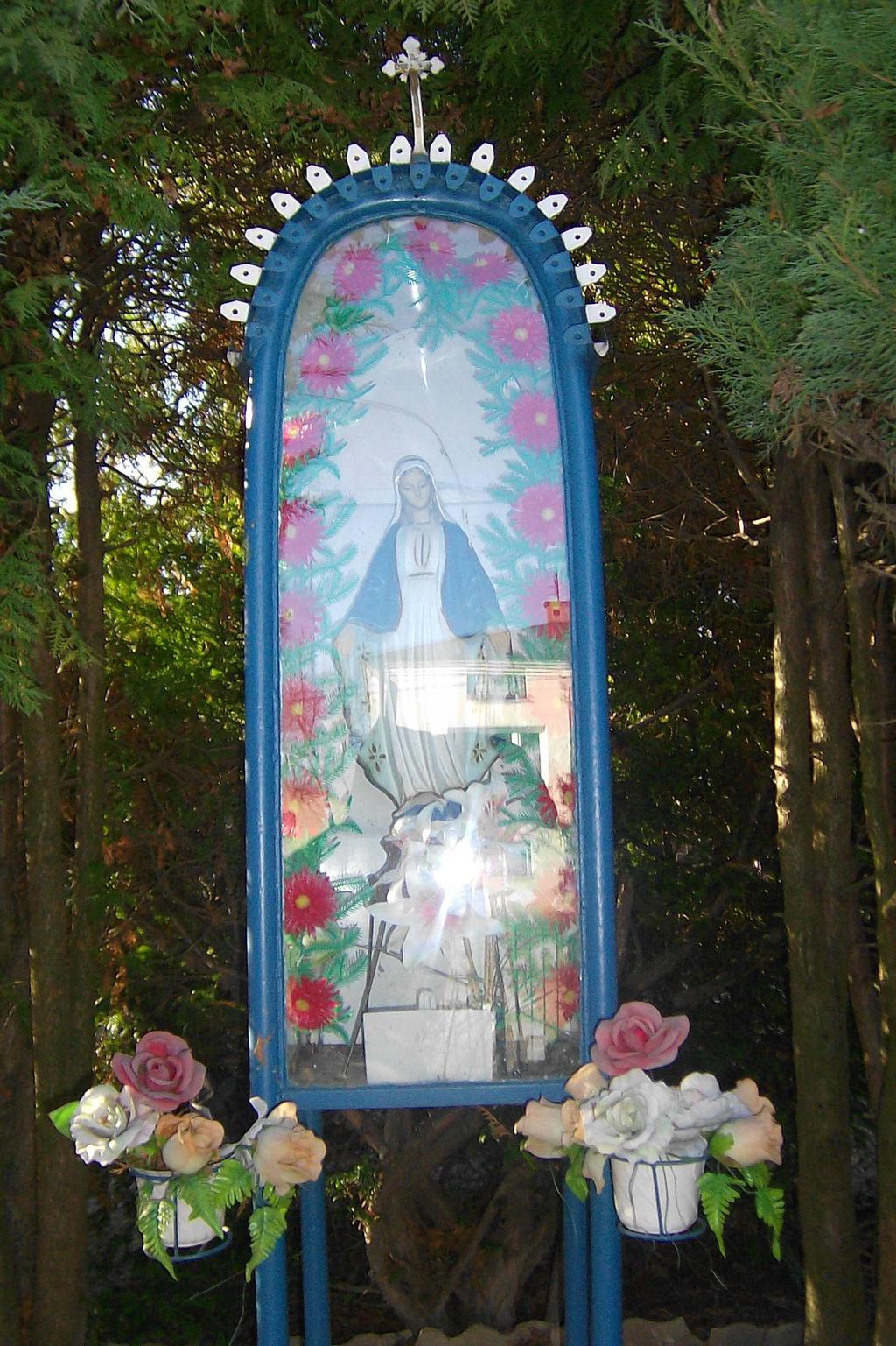 W kapliczce znajduje się figurka Matki Boskiej, która ma otwarte dłonie i szeroko