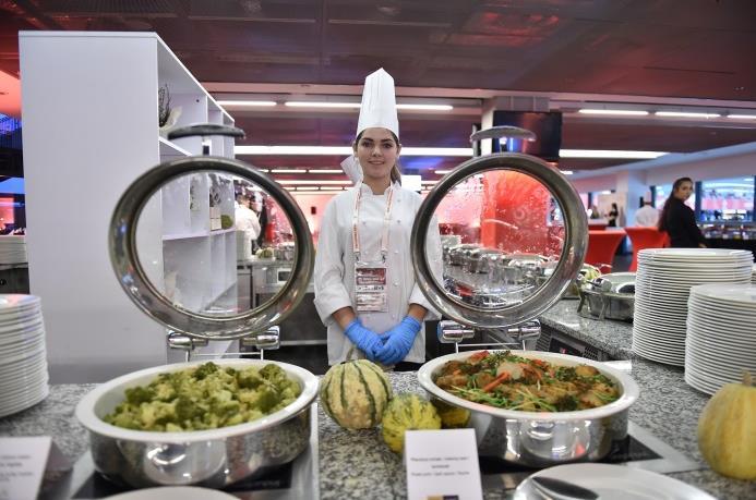 Komfortowe fotele na trybunie głównej znajdują się przed szklaną fasadą restauracji,