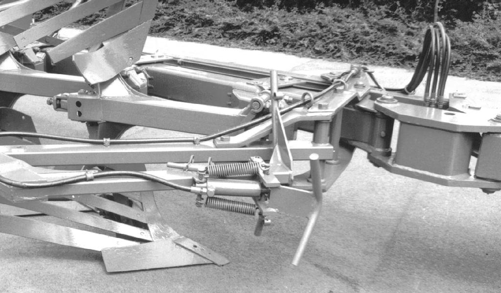 Przy układzie hydraulicznego rozkładania i zabezpieczania, jeśli wał ugniatający - przy podniesionym pługu - ma być przeniesiony ponad przeszkodami, kołki (9/) włożyć do haków mocujących.
