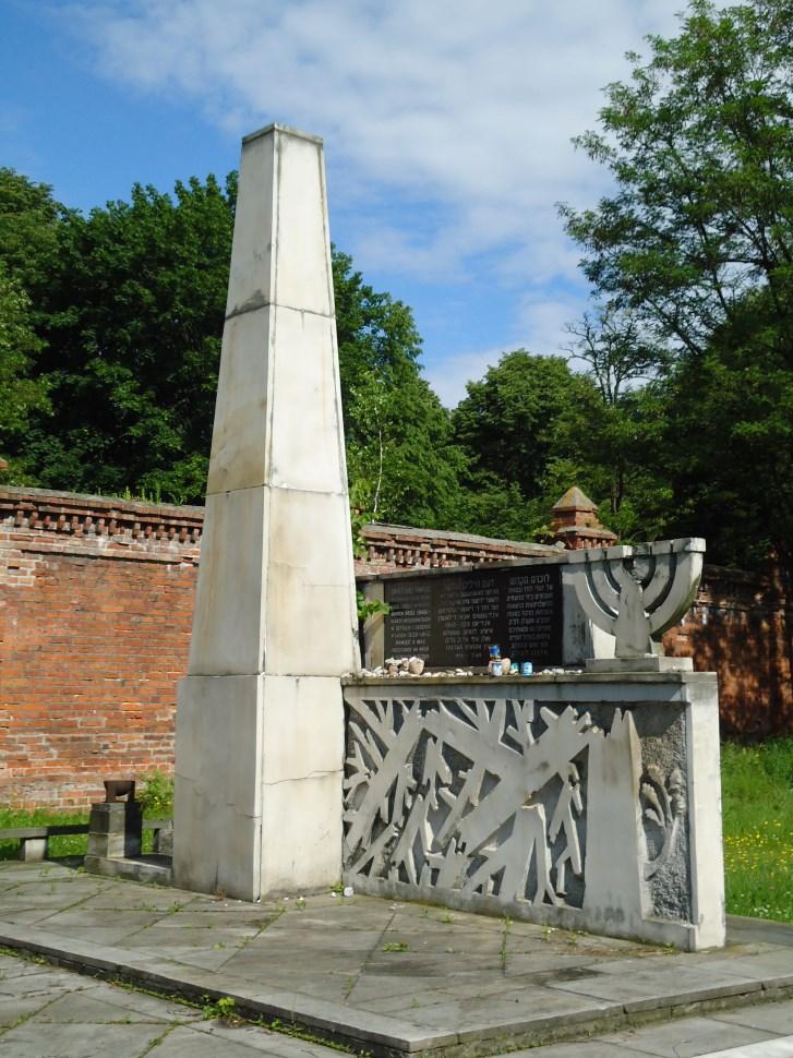 Obelisk Ku Czci Pomordowanych Żydów Po przejściu obok Domu Przedpogrzebowego, kierując się w kierunku cmentarza, znajduje się Obelisk Ku Czci Pomordowanych Żydów.