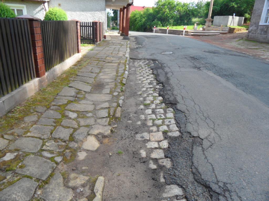 kostki granitowej. Jezdnia ograniczona częściowo jednostronnie krawężnikiem granitowym ułożonym niestabilnie i nieregularnie. Chodniki częściowo z płyt z piaskowca oraz chodnikowych płyt betonowych.