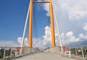 się ulica Kolejowa oraz szeroka, wielotorowa linia kolejowa z trakcją elektryczną. Kładka zlokalizowana jest pomiędzy pasażem w centrum miasta a portem Ekomarina.