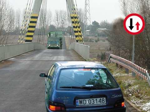 Z040 40 W tej sytuacji kierujący samochodem osobowym powinien: A. zatrzymać się przed mostem, gdyż niemożliwy jest przejazd obu pojazdów, Tak B.
