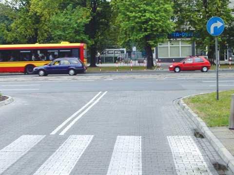 Z056 56 Na tym skrzyżowaniu kierujący pojazdem: A. może skręcić w prawo, Nie B. powinien skręcić w lewo, Tak C. może zawrócić. Nie Z057 57 W tej sytuacji kierujący pojazdem powinien: A.