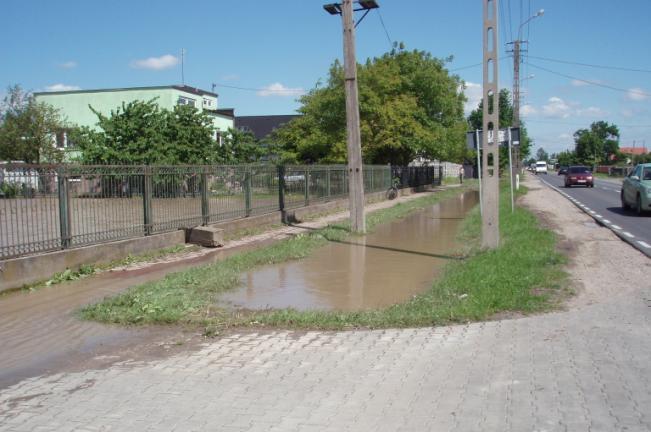 Fot. 1 i 2. Wypełnione po brzegi rowy i zalane posesje w podwarszawskiej miejscowości po opadzie w czerwcu 2010 r. (fot. A.