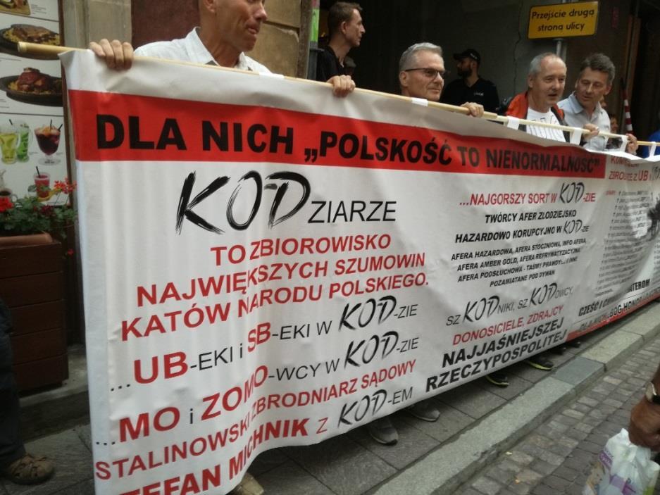 Długi transparent z napisami odnoszącymi się do członków KODu i uczestników
