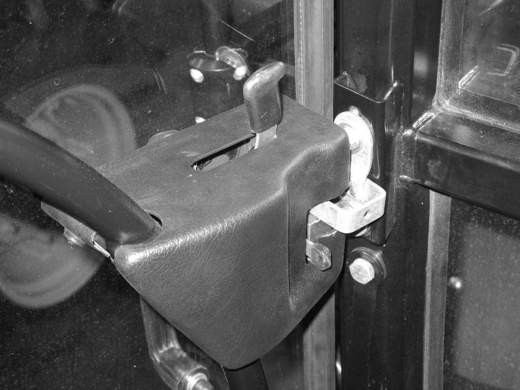 PRONAR 6170 / 6180 ROZDZIAŁ 3 1 2 W celu otworzenia drzwi od wewnątrz należy pociągnąć za dźwignię 1 zwalniającą mechanizm zamka drzwi.