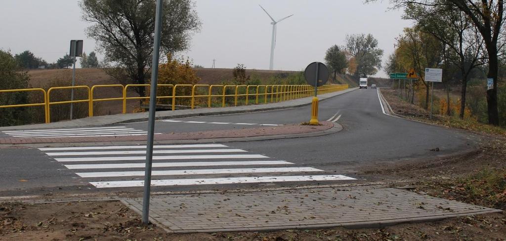 jezdni poprzez wykonanie bitumicznej warstwy wyrównawczej (wiążącej) w ilości 110 kg/m 2 i ścieralnej grubości 4 cm oraz wzmocnieniu poboczy na szerokości 0,5 m.