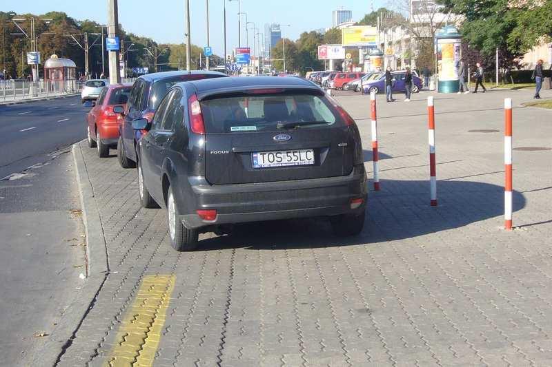 ) Kierowcy wykorzystują obrzeża zatoczek autobusowych jako parking. Fot.. Parkowanie w obrębie węzła.