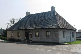 w XIX w., przekształcony na budynek mieszkalny, ob. usługowy. Usytuowany przy skrzyżowaniu ulic w centrum wsi, parterowy, nakryty czterospadowym dachem.