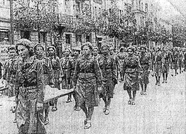 Na zdjęciu przy noszach Jolanta Strawińska z Stanisławą Kiewelówną, za nią Helena Dudówna. Lipiec 1939 r. Zastęp V Drwali godło Toporki na obozie.