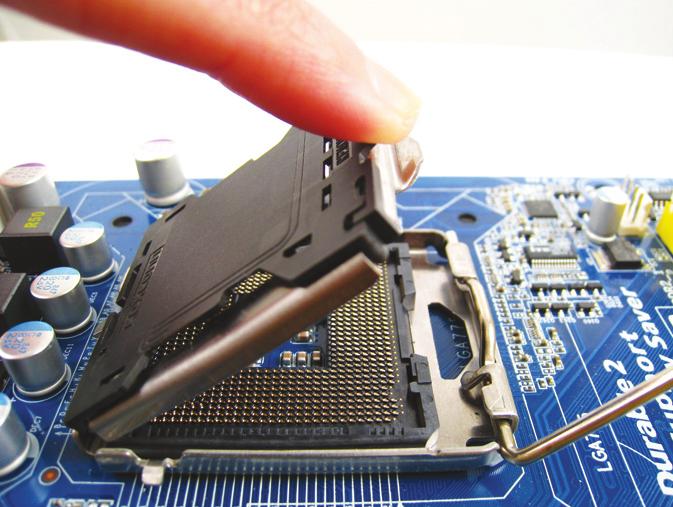 Unieś metalową płytkę na gnieździe procesora. (Nie dotykaj pinów w gnieździe.