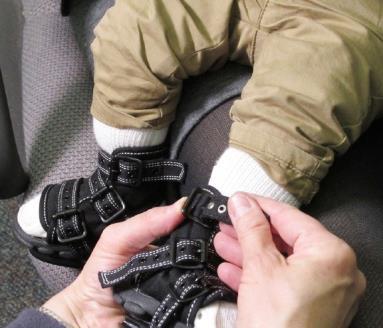 12 8. Sprawdź, czy pięta dziecka nadal znajduje się głęboko z tyłu buta, sprawdzając poprzez okienko kontrolne umiejscowione w tylnej części buta.