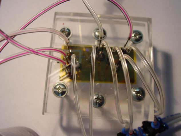 detektorem konduktometrycznym: a) gotowy chip, b) schemat ideowy działania dozownika, c) lab-on-a-chip zamontowany w obudowie z