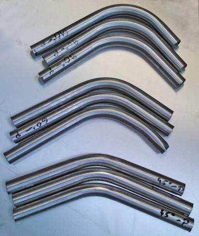 Tube bending tests: a) tube before bending, b) tube after bending Rurki gięto po wypełnieniu ich piaskiem kwarcowym o ziarnistości 1 mm, jak również bez wypełnienia.