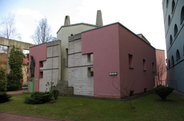 The building has four floors. The side wings from the outside, designed concrete colonnade of exaggerated proportions of elements, which close the outer courtyard.