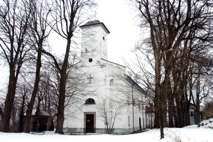 Trójnawowa bazylik z wysokim, wielobocznie zamkniętym prezbiterium ujętym parterowymi aneksami i z wieżą w elewacji zach., nakrytą stromym ostrosłupowym dachem z trójkątnymi szczycikami u nasady.