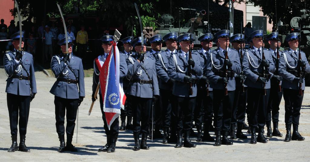 Mężczyźni w ubraniach cywilnych zdejmują nakrycia głowy.