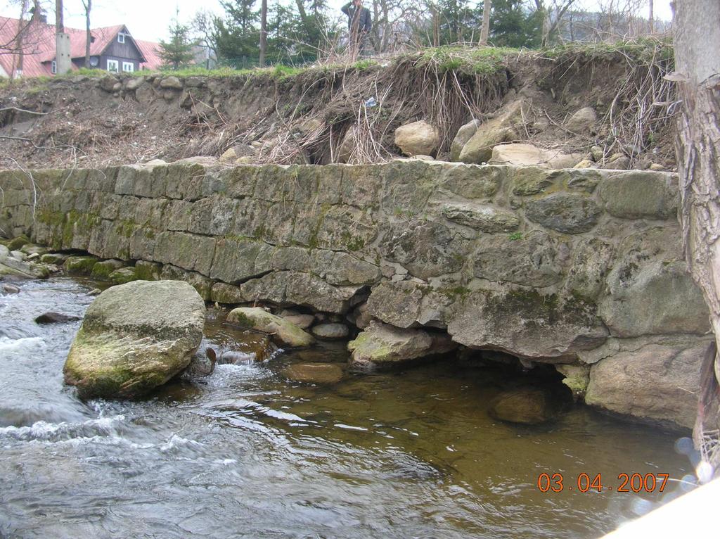 Mur oporowy podtrzymujący skarpę ulicy Zawadzkiego zbudowany jest z otoczaków na słabej zaprawie cementowej i jest licowany