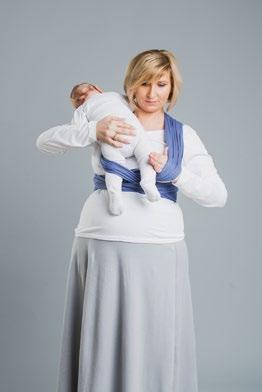 Rozłóż wewnętrzny pas materiału pod pupą dziecka tak, aby jego brzegi sięgały od jednego kolanka do drugiego.