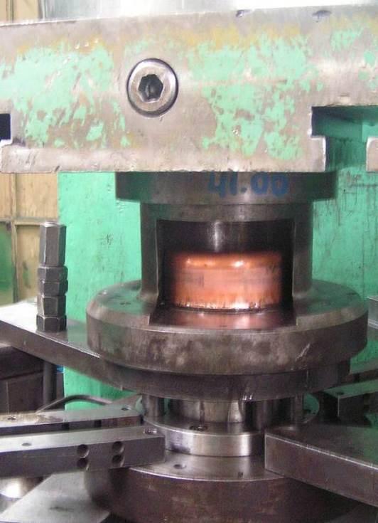 . Testing die for drawing of cylindrical drawpieces, installed on a PHYE-250 press; a) with a visible initial disk for drawing tests mounted on the pressure ring, b) with visible