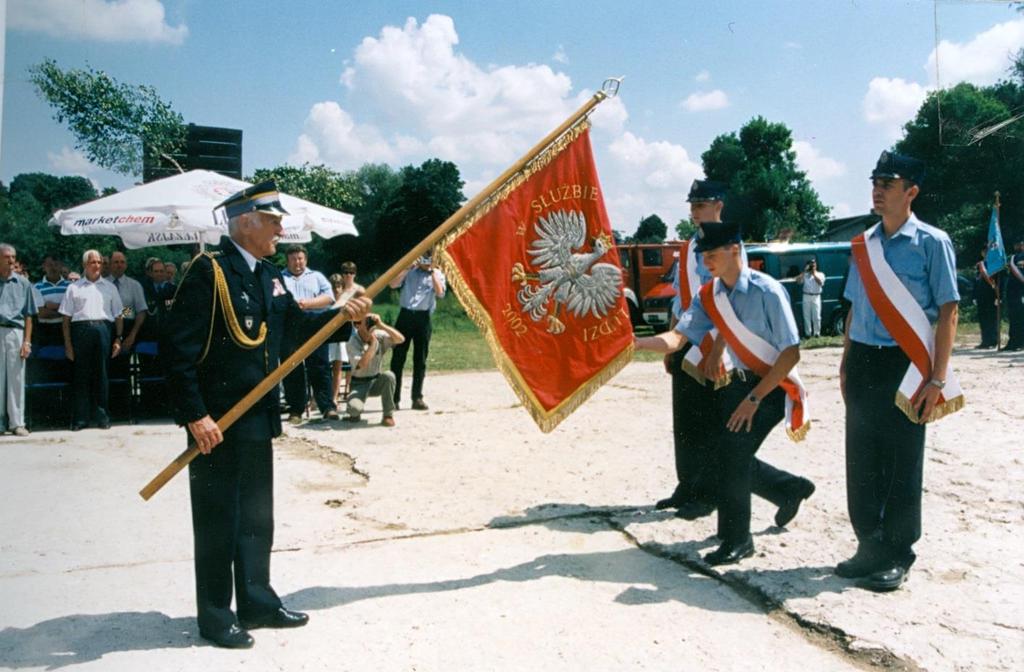 80 Monografia rzymskokatolickiej parafii Świętej Trójcy w Komarowie Zdjęcie 30 Rok 2002, 14 lipca. Przekazanie sztandaru jednostce przez pułkownika Mieczysława Skibę (zdjęcie z KPK T 2).