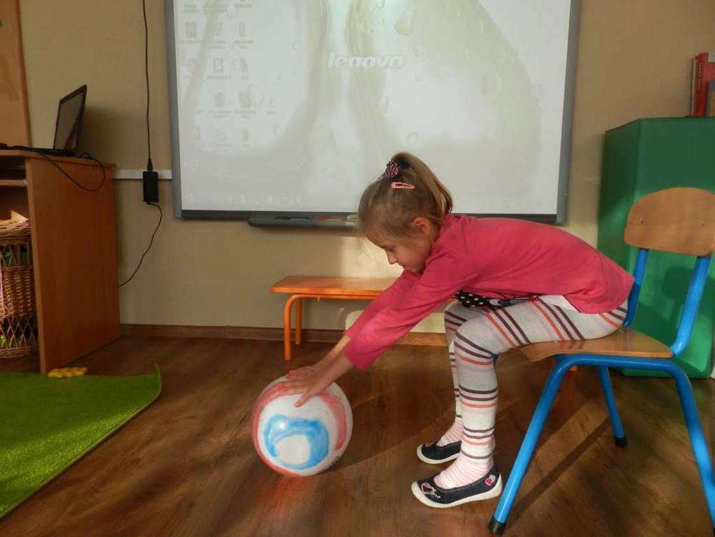 SIĘGANIE PO PIŁKĘ Pochylamy się do przodu, lecz nie na siłę, poddajemy się sile przyciągania ziemskiego. Wykonując skłon klatką piersiową do nóg, staramy się nie napinać mięśni nóg i grzbietu.