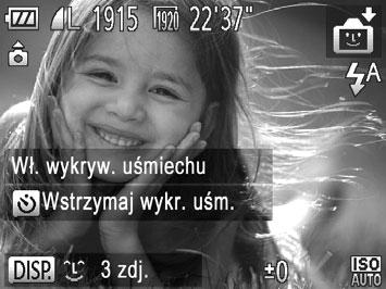 Wybierz ikonę za pomocą przycisków qr lub pokrętła 5, a następnie naciśnij przycisk l. Aparat przejdzie do trybu oczekiwania na fotografowanie i pojawi się komunikat [Wł. wykryw. uśmiechu].