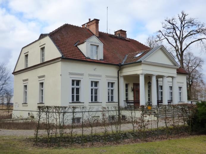Green Key Gminny Program Opieki nad Zabytkami dla Gminy Szubin z kolumnami. Od strony podwórza balkon. Zauważalne opaski tynkowane, okienne oraz gzyms parapetowy, nadokienny i główny.