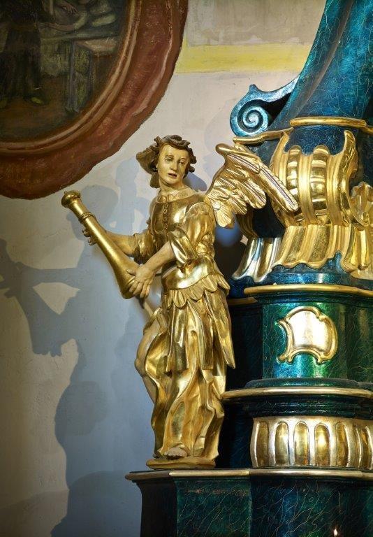 W dolnej części ołtarza znajdują się dodatkowo, jako elementy dekoracyjne dwie figurki aniołów, jeden z nich trzyma w dłoniach krzyż.