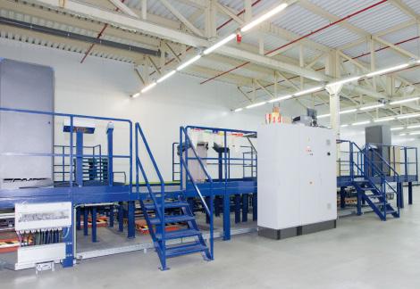 Po obu stronach operatora są hydrauliczne stoły podnośnikowe zapewniające ergonomiczną pozycję