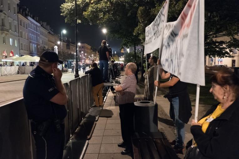 3. Zgromadzenie kontrdemonstrantów stojących przy barierkach na trasie przemarszu zgromadzenia cyklicznego od Placu Zamkowego do ul.