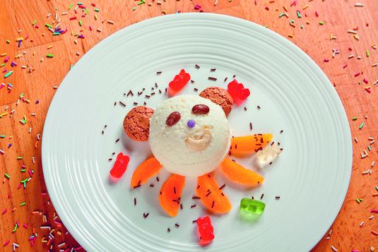 Dobre lody śmietankowe z owocami "Egzotyczny miś" Algida Śmietankowa Trio Tropicana ciasteczka migdałowe, Amaretti 2 sztuki czekoladowe drażetki w kolorowej polewie pomarańcza 1 sztuka czekoladowa