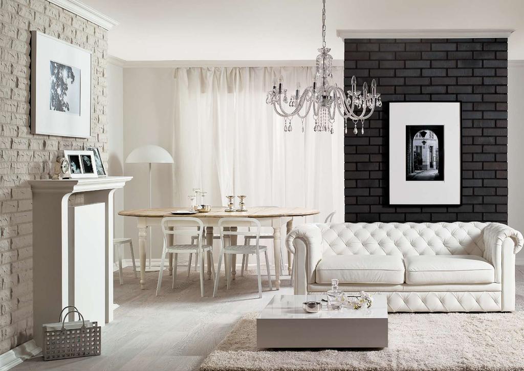 Salon w stylu glamour i jego atrybuty eleganckie kanapy, kryształowy żyrandol, stylowe dodatki prezentują się jeszcze efektowniej na tle klinkierowych ścian.
