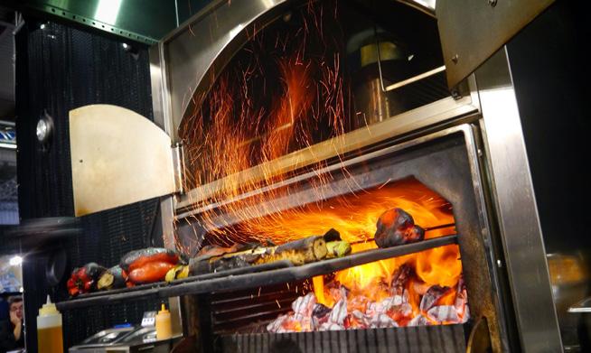 Technologia Cold Mist tworzy kurtynę zimnej mgły wodnej w przestrzeni wyciągowej okapu, przez którą przepływa dym generowany przez urządzenie gastronomiczne.