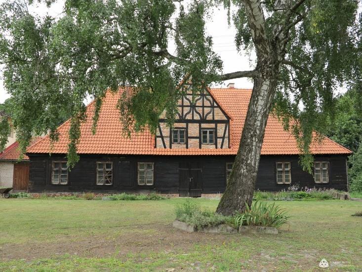 Łączy elementy polskie (zrębowe przyziemie) i charakterystyczne dla Pomorza poddasze tzw.