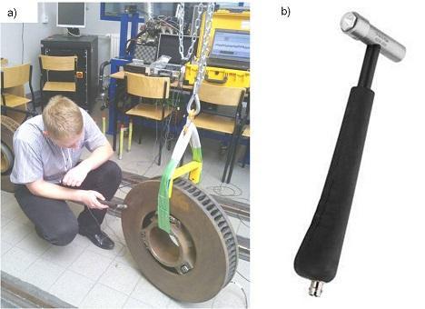 Rys. 1. Test impulsowy: a) realizacja eksperymentu, b) widok młotka modalnego typu 8206-002 Do rejestracji sygnałów drgań oraz wymuszeń zastosowano Multianalizator PULSE firmy Brüel&Kjær.