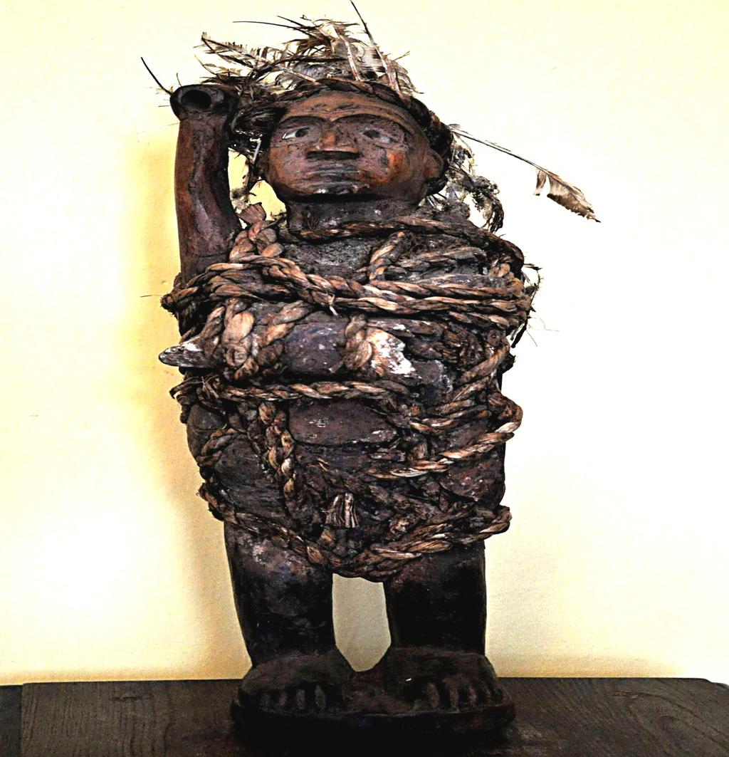 Zdjęcie po lewej Bakongo, wieśniaczy fetysz Chingune z prawym ramieniem wzniesionym w groźnym geście, oczy ze szkła, do korpusu przywiązane kości zwierzęce.