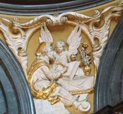11 39 Powyżej, na gzymsie, umieszczono dwie figurki klęczących aniołków, podtrzymujących koronę, a przyczółek zwieńczenia nad nimi ozdobiono groteskową maską w formie wolutowej klamry.