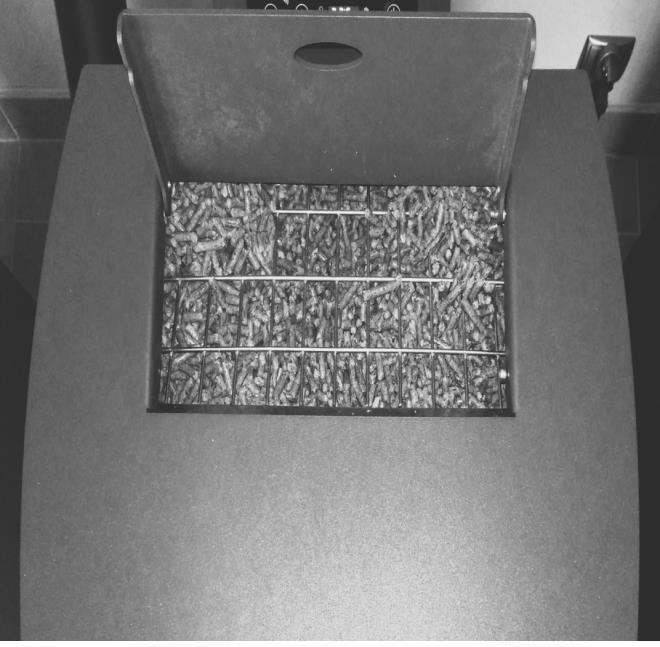 ŁADOWANIE PELLETU Paliwo,,pellet jest ładowane w górnej części piecyka, po otwarciu pokrywy. Pojemność zbiornika około 10 kg pelletu.