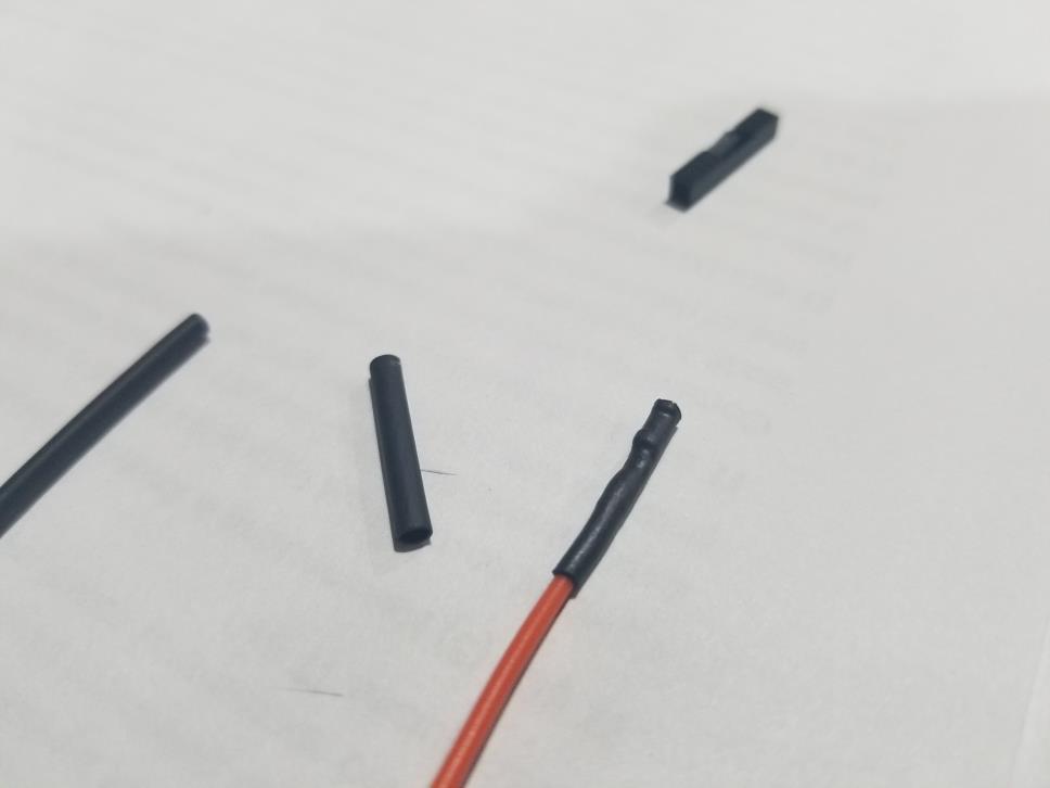 3. Wsuń koszulkę na kabel zakrywając nie zaizolowany drut i ogrzej
