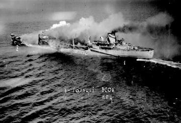 Około 11:38 okręt otrzymuje wiele trafień bomb i prawdopodobnie torped w część dziobową, które powodują poważne uszkodzenia i ogromny pożar części dziobowej oraz dziobowej nadbudówki.
