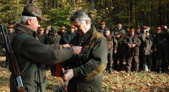 Sygnaliści stają po stronie grzbietowej zwierzyny (prawej od prowadzącego polowanie) i grają sygnał Zbiórka myśliwych.