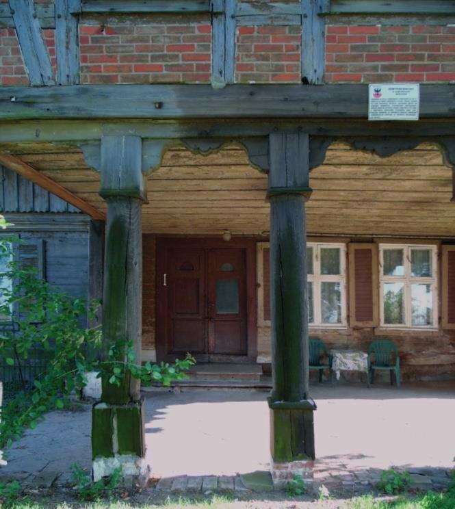 Słupy drewniane o wysokości 230 cm, przekrój kołowy o promieniu 17 cm, proste bez ozdób, widoczne pęknięcia, słupy mają niewielki zielony nalot, osadzone na murowanych