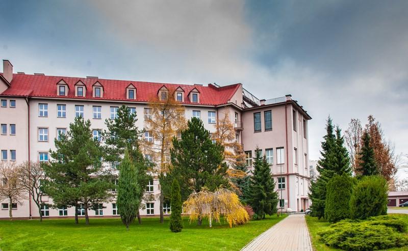 Za kościołem wznosi się ogromny budynek z dachem pomalowanym na fioletowo, wybudowany w latach 1927-1931 według projektu architekta Jerzego Siennickiego, który został przeznaczony na