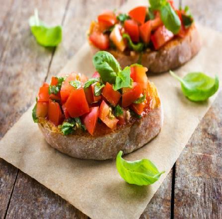 BRUSCHETTA KLASYCZNA POTRZEBNE SKŁADNIKI: ciabatta Bułkę pokrój na równe, niezbyt grube kromki. Dwa ząbki czosnku obierz i przeciśnij przez praskę, a jeden podziel na połówki.